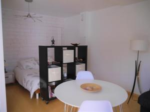 einen weißen Tisch und Stühle in einem Zimmer mit einem Bett in der Unterkunft Studio de Fontaine in Fontaine-le-Comte