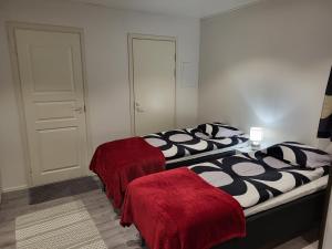 two beds in a room with red blankets on them at Guest House Koskenkylä in Rovaniemi