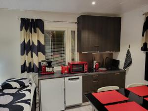 Una pequeña cocina con microondas y una cama. en Guest House Koskenkylä, en Rovaniemi