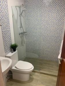 uma casa de banho com um WC e uma cabina de duche em vidro. em Hotel Conquistador Santo Domingo em Santo Domingo