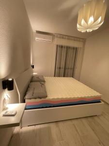 1 dormitorio con 1 cama, 1 mesa y 1 lámpara en APPARTAMENTO VACANZE A 300mt dal mare!, en Silvi Paese