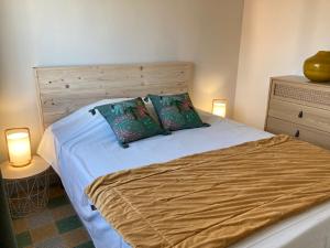 - une chambre avec un lit avec deux oreillers et deux lampes dans l'établissement Joli appartement avec vue mer, à Narbonne