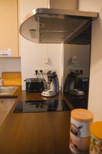 a kitchen counter with two coffee makers on a stove at Au Reflet Du Pont in La Rivière Saint Sauveur