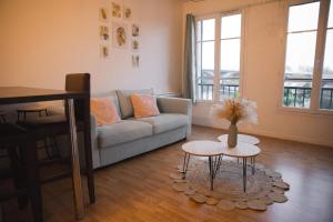 a living room with a couch and a table at Au Reflet Du Pont in La Rivière Saint Sauveur