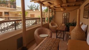 a balcony with wicker chairs and tables on a balcony at Riad Dar Eternity in Marrakech