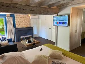 een slaapkamer met een bed en een tv aan de muur bij Auberge de la Caillère - Teritoria in Candé-sur-Beuvron