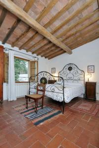 a bedroom with two beds and a chair and a window at Castello di Bibbione in San Casciano in Val di Pesa +61 photos