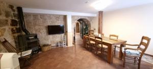 a dining room with a table and a tv in a room at Casa Rural de Lucía in Horche