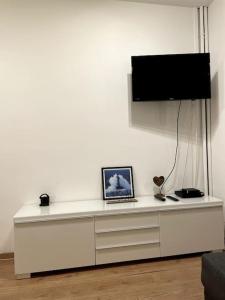 uma cómoda branca com uma televisão por cima em Superbe Appartement Paris 16 em Paris