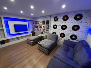 a living room with a couch and a wall with records at 3 Separate Beds Central Apartment - 40m2 in Budapest
