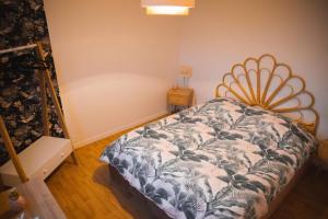 a bedroom with a bed in the corner of a room at Au Reflet Du Pont in La Rivière Saint Sauveur