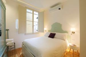 a bedroom with a white bed and a window at Ariento 9 in Florence