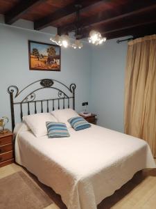 a bedroom with a white bed with blue pillows at Pikua Landetxea in Mutriku