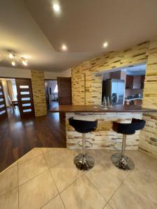 a kitchen with a counter and two bar stools at Apartament Pieniny Dream in Krościenko