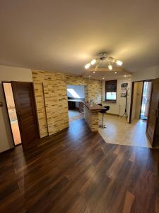 a large living room with a table and a stone wall at Apartament Pieniny Dream in Krościenko