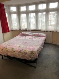 a bedroom with a bed with a floral bedspread at North London Rooms in London