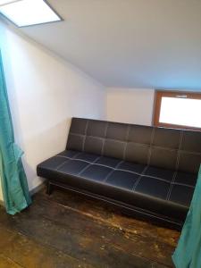 a black couch in a room with a window at Studio tout équipé plein centre-ville de Limoges in Limoges