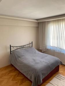a bedroom with a bed and a large window at Etilerde metroya yakın sakin sessiz ve ferah daire in Istanbul