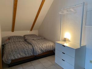 a small bedroom with a bed and a dresser at FEWO Eggenstein beim KIT in Eggenstein-Leopoldshafen