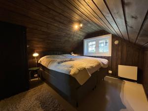 een bed in een kamer met een houten plafond bij Fin leilighet med flott beliggenhet ski in ski out in Beitostøl