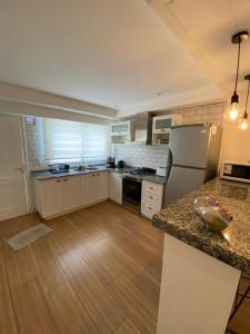a kitchen with white appliances and a wooden floor at ROMA apartamento frente al mar in Mar del Plata