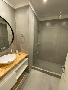 y baño con ducha, lavabo y espejo. en ROMA apartamento frente al mar en Mar del Plata