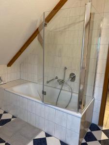 a bath tub with a glass shower in a bathroom at FEWO Eggenstein beim KIT in Eggenstein-Leopoldshafen +36 photos
