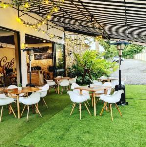 een restaurant met tafels en stoelen op het gras bij Casa Hotel Bremen in Circasia