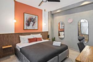 um quarto com uma cama com uma parede laranja em Old City Boutique - בוטיק העתיקה מבית רשת מלונות לה פינקה em Bersebá