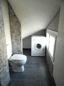 a bathroom with a toilet and a washing machine at Homing Volos Exclusive Luxury Residence in Volos