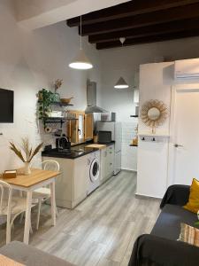 eine Küche und ein Wohnzimmer mit einem Tisch und einer Küche in der Unterkunft Loft Xera - parking privado in Jerez de la Frontera