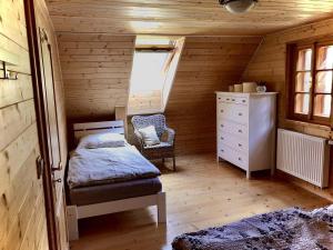 een slaapkamer met een bed en een stoel in een hut bij Pod Hradem v Jeseníkách in Hanušovice