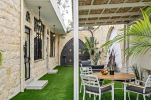 a patio with green grass and a table and chairs at Old City Boutique - בוטיק העתיקה מבית רשת מלונות לה פינקה in Beer Sheva