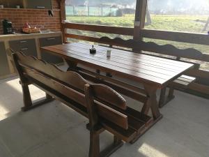 drewniany stół i ławka w kuchni w obiekcie Căsuțe Zăvoi Bulz w mieście Bulz