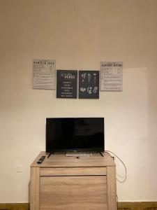 a tv on top of a dresser with signs on the wall at Casa Andrea in Ghedi