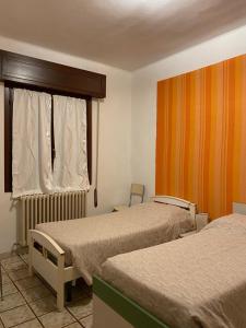 um quarto de hotel com duas camas e uma janela em Casa Andrea em Ghedi
