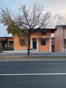 a house on the side of a street with a tree at Casa Andrea in Ghedi