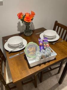 a wooden table with plates and a tray of food at *Close to Beach* One Bedroom Suite with Parking in Overstrand