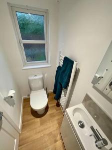 a small bathroom with a toilet and a window at *Close to Beach* One Bedroom Suite with Parking in Overstrand