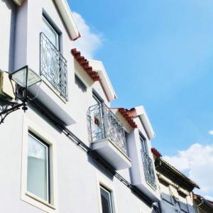 ein Gebäude mit Balkon und blauem Himmel in der Unterkunft O 21 da Vila in Seia