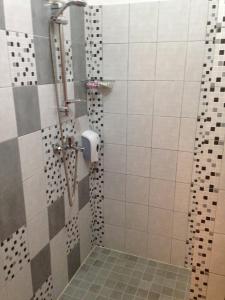 a bathroom with a shower with a tiled floor at Draft ROOM in Valpovo