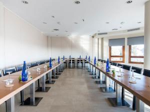 a large room with long tables and blue vases at Hotel Plaza Las Matas in Las Rozas de Madrid