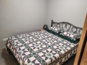ein Bett mit einer Decke und zwei Kissen darauf in der Unterkunft Casa da Guida in Angra do Heroísmo