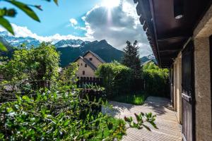 a balcony of a house with a view of mountains at Serre Chevalier Monêtier les Bains T3 jardin Appartement les Mélèzes in Le Monêtier-les-Bains