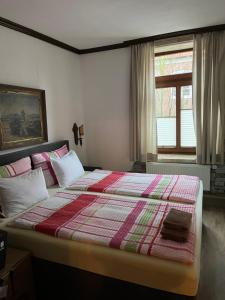 a bedroom with a large bed with a quilt on it at Restaurant- Hotel- Biergarten Haduloha in Otterndorf