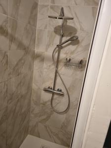 a shower with a hose in a bathroom at Studio du lac bleu in Morillon