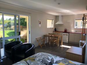 a kitchen and living room with a table and chairs at Totara Cottage in Twizel