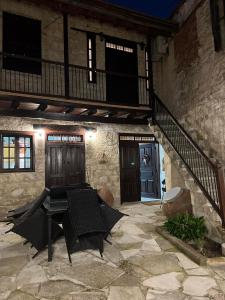 a patio with a table and an umbrella in front of a building at Stou Pavli in Arsos