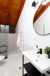 a bathroom with a white sink and a mirror at One Love Central Cottage in Bucharest