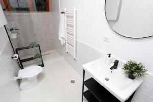 un bagno con un water, un lavandino e uno specchio di One Love Central Cottage a Bucarest